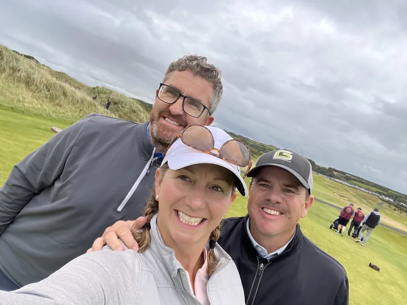 Griffin Golf travelers smiling together on a course overlooking the water