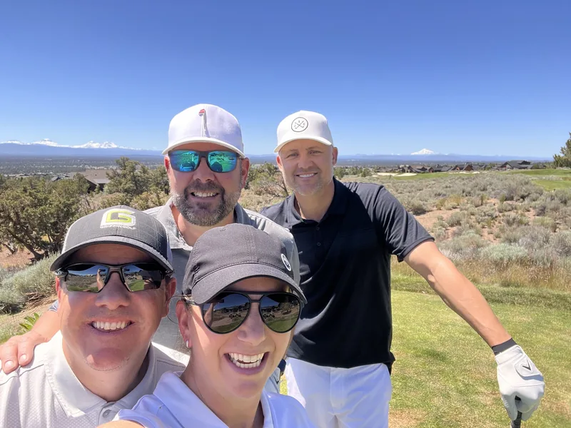 Four travelers standing together on a mountain golf course